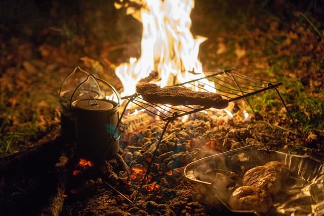 steak cooking on campfire