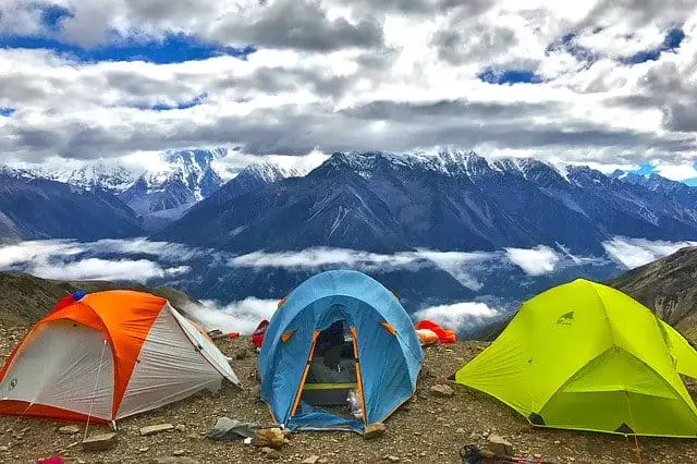 orange, blue, and yellow tents on mountain