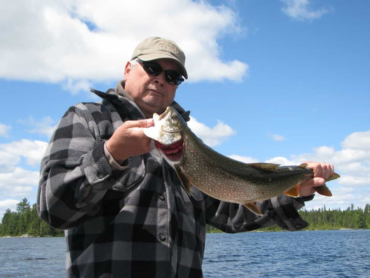 fisherman holding lake trout