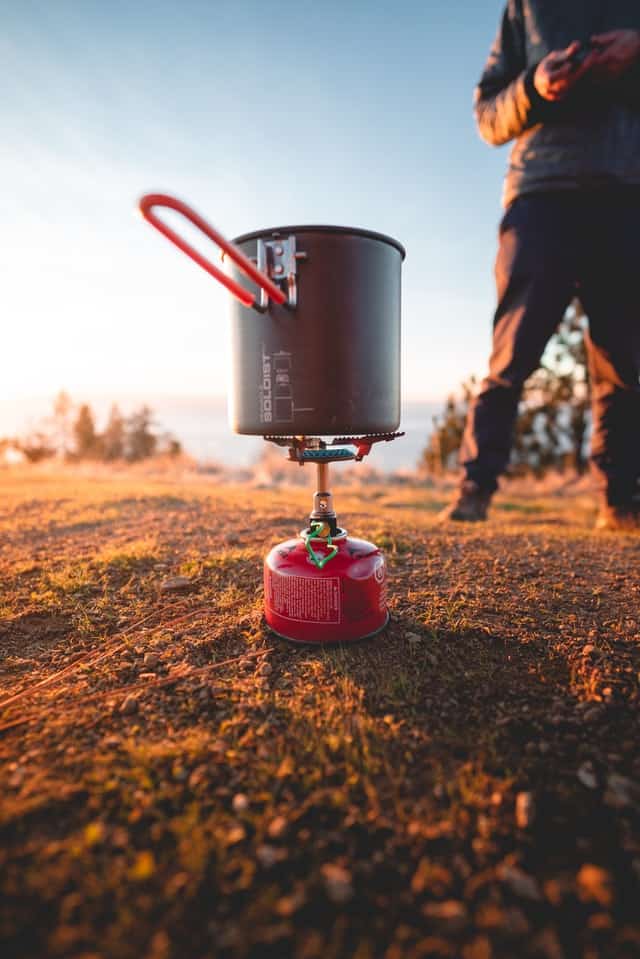 backpacking stove cooking on ground